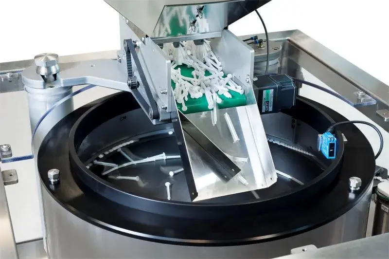 Close-up of a centrifugal feeder orientating white plastic components